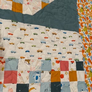 May include: A patchwork quilt with a variety of colorful fabrics and patterns. The quilt features a blue, yellow, and pink color scheme. The quilt is made up of squares and rectangles, and the fabric is quilted with a variety of designs. The quilt is a great way to add a touch of color and personality to any room.