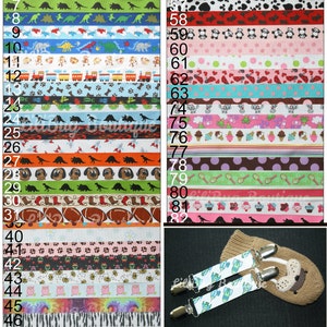 May include: A collection of colorful patterned ribbon with various designs, including dinosaurs, animals, and geometric patterns. The ribbon is displayed on a white background with numbers indicating each ribbon's position. A pair of white clips with a rocket ship design are also shown.