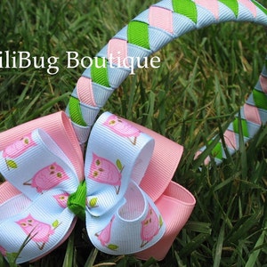 May include: A headband with a pink and green braided design and a matching bow with a white background and pink owls printed on it.
