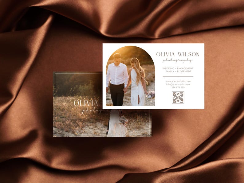 May include: A white business card with a photo of a couple walking on a beach at sunset. The text on the card reads "Olivia Wilson Photography" and includes contact information and a QR code.