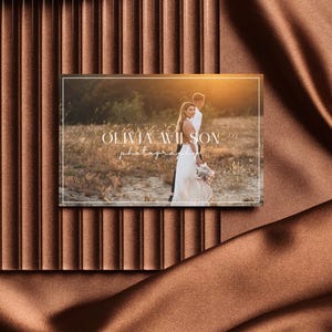 May include: A white business card with a photograph of a couple in a field. The text on the card reads "Olivia Wilson Photography".