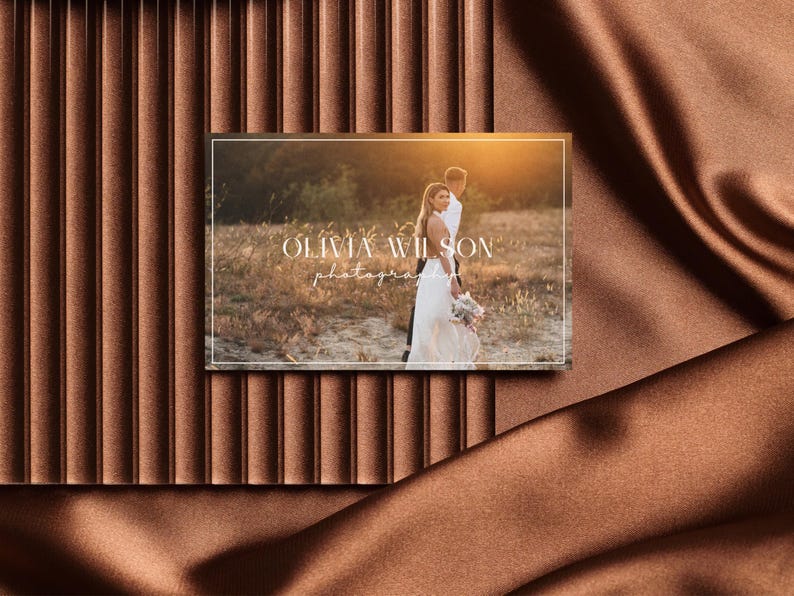 May include: A white business card with a photograph of a couple in a field. The text on the card reads "Olivia Wilson Photography".