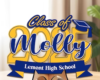 May include: A wooden graduation sign with the text "Class of 2025 Molly" in blue script and yellow block letters. A blue banner reads "Lemont High School." The sign includes a graduation cap and a wooden stand.