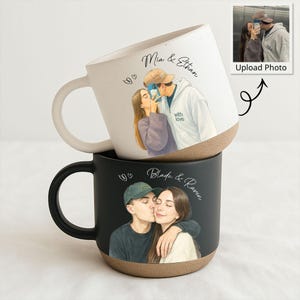 May include: Two ceramic mugs, one white and one black, each featuring a custom illustration of a couple. The white mug has a beige base and a white handle, with the names "Mia & Ethan" and a drawing of a couple kissing. The black mug has a beige base and a black handle, with the names "Blade & Raven".