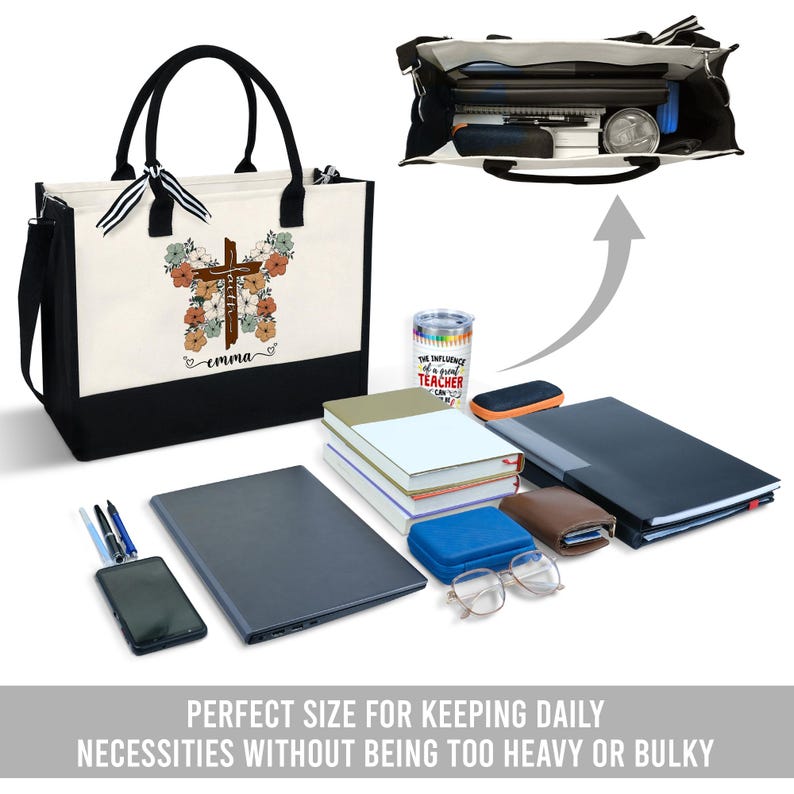 May include: A black and white canvas tote bag with a brown cross and floral design. The bag has a black bottom and a black strap. The bag is personalized with the name "emma".