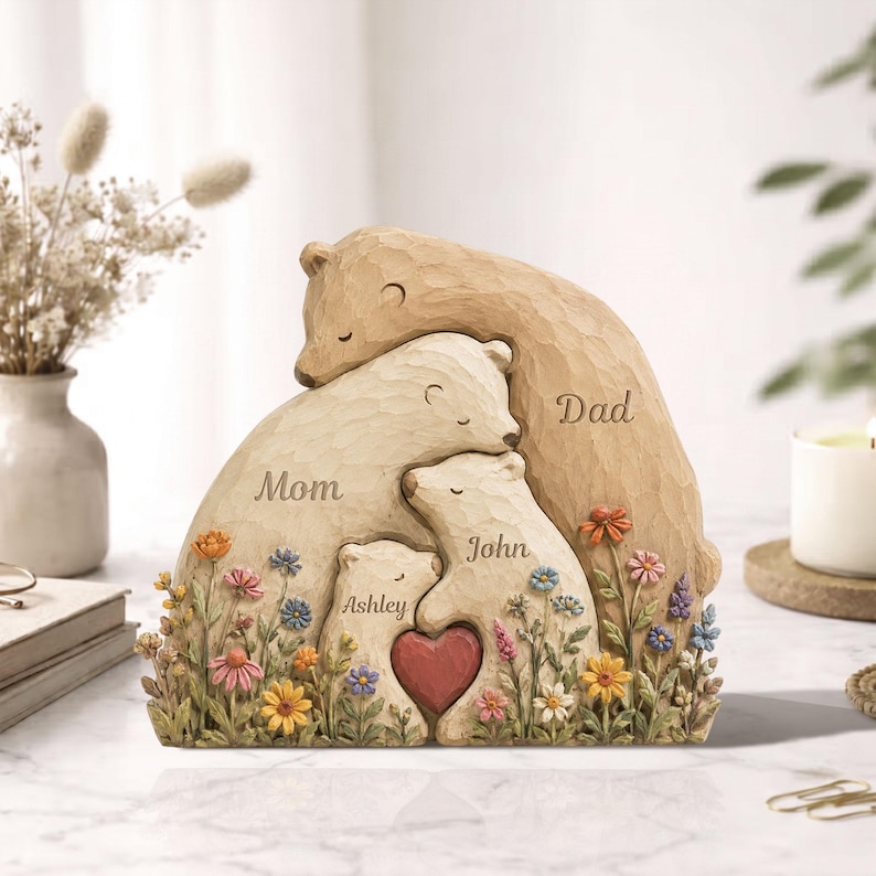K&ouml;nnte beinhalten: Eine geschnitzte Holzskulptur einer B&auml;renfamilie. Die Skulptur zeigt eine Mutter, einen Vater und zwei Kinder, die sich umarmen, mit den Namen "Mom", "Dad", "John" und "Ashley" in die B&auml;ren geschnitzt. Ein rotes Herz befindet sich in der Mitte.