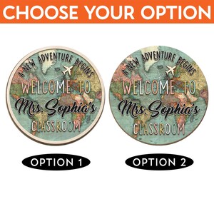 May include: Two round classroom signs with a world map design. The signs read "A New Adventure Begins, Welcome to Mrs. Sophia's Classroom." Option 1 has a light wood border, while Option 2 has a darker border.