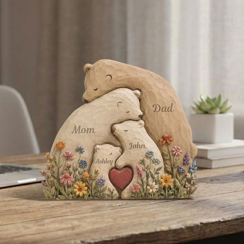K&ouml;nnte beinhalten: Eine geschnitzte B&auml;renfamilien-Skulptur mit den Worten "Mama", "Papa", "Ashley" und "John". Die Skulptur zeigt ein Herz und bunte Blumen. Die B&auml;ren sind in Beige- und Braunt&ouml;nen gehalten.