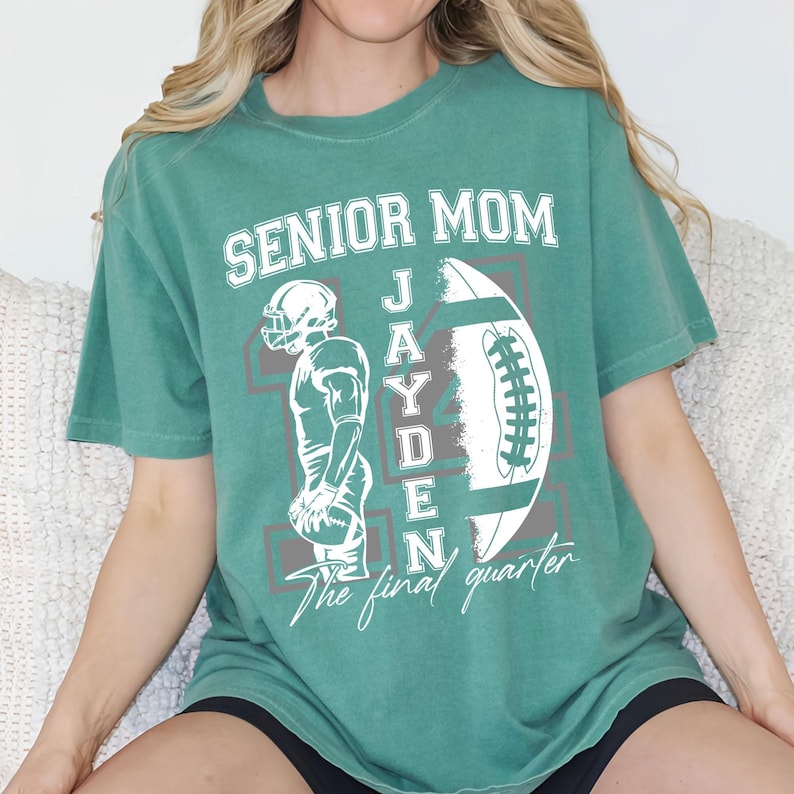 May include: Green t-shirt with the text "SENIOR MOM" above a football graphic and the name "JAYDEN". A football player illustration is on the left. The words "The final quarter" are below the football.