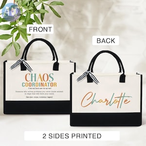 May include: A white canvas tote bag with black handles. The front of the bag has the text "Chaos Coordinator" with a definition and the back of the bag has the name "Charlotte" in colorful script. The bag is printed on both sides.