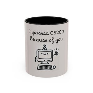 May include: White ceramic mug with a black interior. The mug features the text "I passed CS200 because of you" and a cartoon computer with a party hat. The computer is giving a thumbs up.