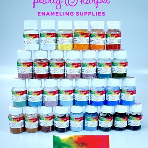May include: A collection of small jars of enamel paint in various colors, arranged in a pyramid shape. The jars are labeled "True Colors" and are from the brand "pearly @ karpel enameling supplies".