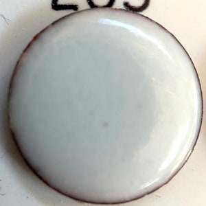 May include: A white ceramic tile with the number 203 printed on it.