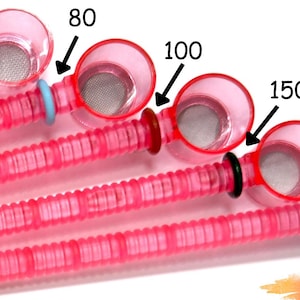 May include: Six pink sifters with different mesh sizes, labeled 40, 60, 80, 100, 150, and 200. The sifters are arranged in a row from smallest to largest.  The text "Sifter's Mesh Sizes" is at the top of the image. The text "Pearly's Supply" is at the bottom of the image.