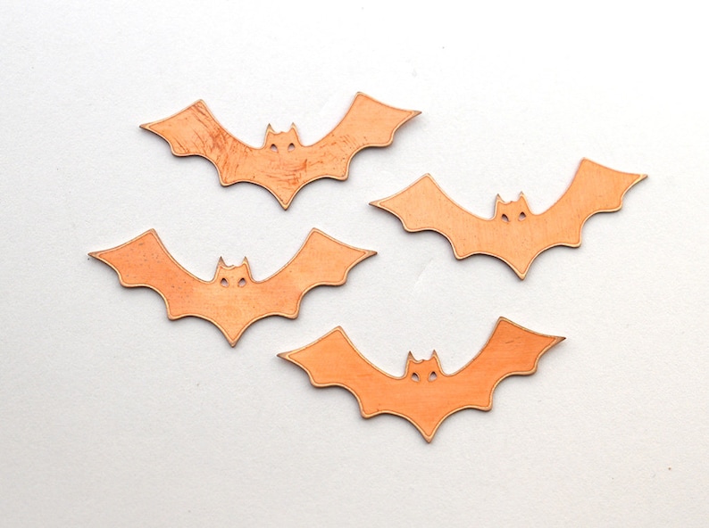 K&ouml;nnte beinhalten: Vier orangefarbene Papierflederm&auml;use mit einem einfachen Design. Die Flederm&auml;use sind ausgeschnitten und haben eine leicht strukturierte Oberfl&auml;che.