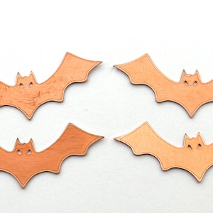 K&ouml;nnte beinhalten: Vier orangefarbene Papierflederm&auml;use mit ausgeschnittenen Augen. Die Flederm&auml;use sind in zwei Reihen zu je zwei angeordnet.