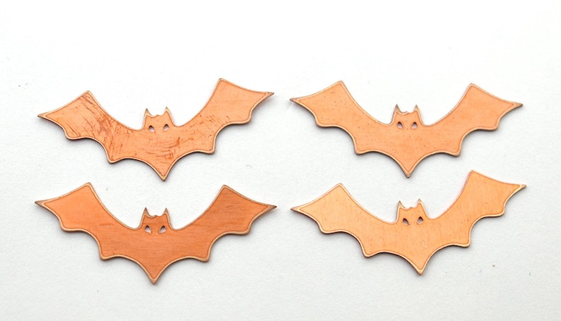 K&ouml;nnte beinhalten: Vier orangefarbene Papierflederm&auml;use mit ausgeschnittenen Augen. Die Flederm&auml;use sind in zwei Reihen zu je zwei angeordnet.