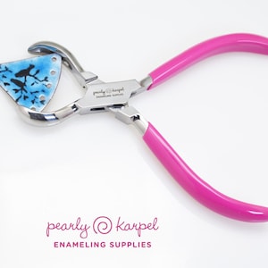 Op de afbeelding: Roze emailleer tang met een zilveren metalen frame en een blauw en zwart emaille stuk in de bekken. De tang is gelabeld "pearly @ karpel enameling supplies".