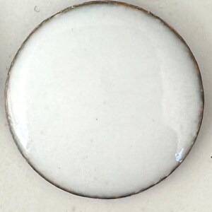 May include: A white ceramic tile with a smooth, glossy finish.