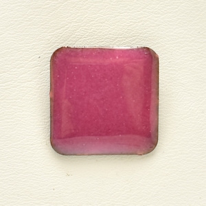 Pode incluir: Um azulejo quadrado de esmalte rosa com um acabamento ligeiramente iridescente.