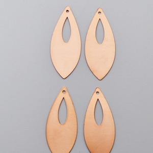 May include: Four copper-colored teardrop earrings with a cutout design. Each earring has a small hole at the top for hanging. The earrings are displayed on a gray background.