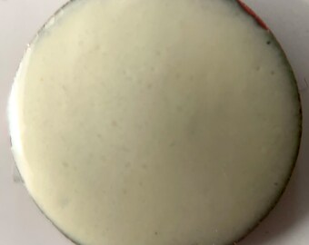 May include: A white round button with a slightly raised edge. The button has a smooth, glossy finish.