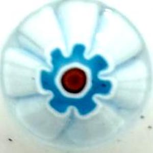 May include: A white glass bead with a blue and red center. The bead has a flower-like design with white lines radiating from the center.