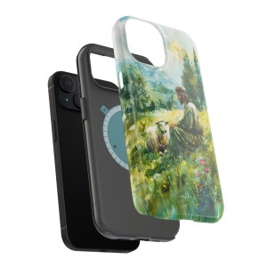 May include: A black phone case with a colorful image of a man sitting with a sheep in a field. The image is a watercolor painting with green grass, blue sky, and a bright sun.