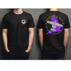May include: Black t-shirt featuring a circular logo on the front and a graphic on the back. The back graphic includes an airplane over a purple map, with the text "BUZZARDS RULE" and "510th Tactical Fighter Squadron - RAF Bentwaters - UK."