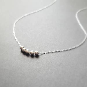 May include: A silver necklace with a row of small, round beads.