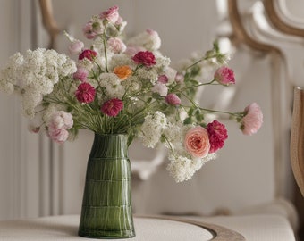 Cool flowers in a vase on top of a counter with bright colours