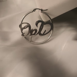 Puede incluir: Pendientes de aro de plata con el nombre "Opal" escrito en cursiva.