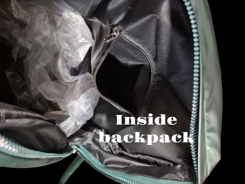 Peut inclure: L'int&eacute;rieur d'un sac &agrave; dos vert avec une fermeture &eacute;clair. Le sac &agrave; dos est ouvert et l'int&eacute;rieur est noir.