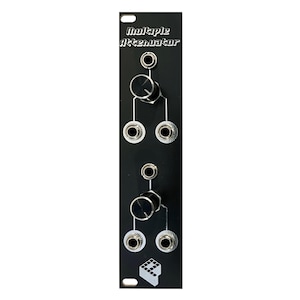 Peut inclure: Panneau en métal noir avec le texte "Multiple Attenuator" et quatre prises jack argentées, deux boutons et un petit logo.