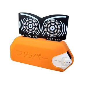 Peut inclure: Un appareil électronique orange avec un dessus noir comportant deux réseaux de lumières circulaires. L'appareil porte du texte japonais sur le côté et un panneau de commande blanc. Le dessus ressemble à des yeux stylisés.