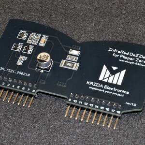 Puede incluir: Placa de circuito electr&oacute;nico negra con pines dorados, etiquetada como "InfraRed DaZZler for Flipper Zero". Cuenta con varios componentes y el texto "KRIDA Electronics" y "rev1.0".