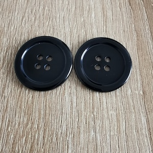 May include: Two black plastic buttons with four holes each.