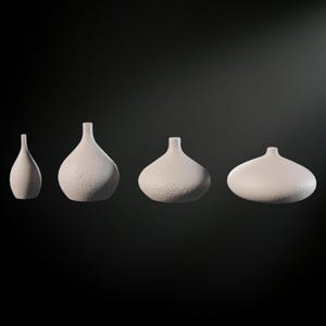 May include: Four white ceramic vases of varying sizes and shapes. The vases are all textured and have a matte finish.