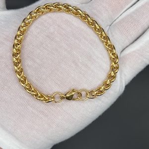 May include: A gold chain bracelet with a lobster clasp closure.