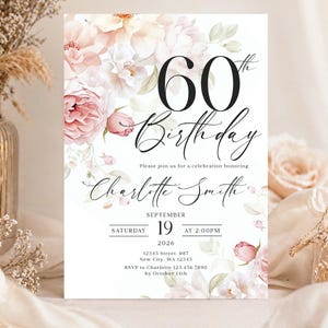 Pode incluir: Um convite de aniversário de 60 anos branco com detalhes florais. O design apresenta um arranjo em aquarela de flores rosa e brancas. O texto inclui o nome, a data, a hora e as informações de RSVP.