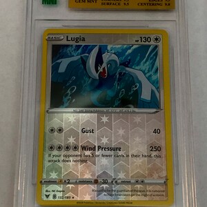 May include: A Pokemon trading card featuring Lugia, a blue and white diving Pokemon with a wingspan of 171 inches and a weight of 476.2 pounds. The card is from the Vivid Voltage set and is a reverse foil rare card. The card number is 132/185.
