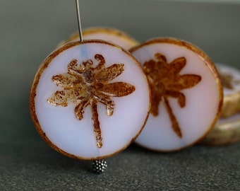 May include: White glass beads with a brown dragonfly design. The beads are round and have a smooth, glossy finish.