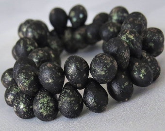 May include: A strand of black and green speckled beads, each bead is shaped like a teardrop.