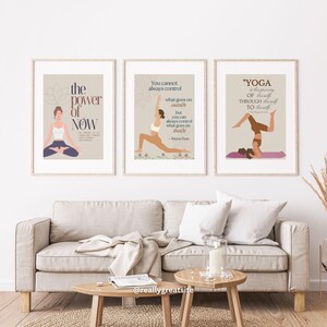 Puede incluir: Tres impresiones artísticas enmarcadas con ilustraciones temáticas de yoga y citas inspiradoras. Las impresiones presentan figuras en posturas de yoga, con texto que incluye "The Power of Now" y una cita de Wayne Dyer. La paleta de colores incluye beige, marrón y blanco.