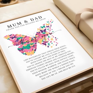 May include: A framed print featuring a butterfly design composed of colorful butterflies. The text reads "MUM & DAD THANK YOU FOR HELPING ME GROW" and a poem about love and gratitude. The frame is light brown.