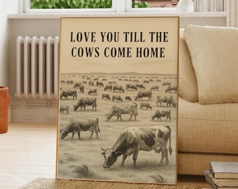May include: A framed print featuring a sepia-toned illustration of cows grazing in a field. The text "LOVE YOU TILL THE COWS COME HOME" is printed at the top. The artwork is displayed in a living room setting, resting on a rug.
