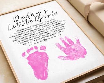 Può includere: Una stampa incorniciata con il testo "Daddy's Little Girl!" e una poesia. La stampa include un'impronta di mano e di piede rosa. La cornice è marrone chiaro.