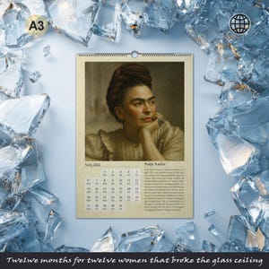 May include: A3-sized calendar featuring a portrait of Frida Kahlo, with the month of July 2021 displayed. The calendar includes a quote and a calendar grid. The phrase "Twelve months for twelve women that broke the glass ceiling" is at the bottom.