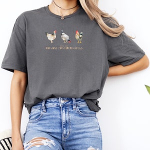 May include: A grey t-shirt with a graphic of three chickens and the text "Keine Zeit, ich muss zu meinen M&auml;dels".