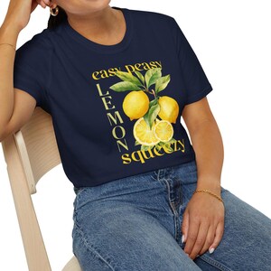 May include: Navy blue t-shirt with a yellow lemon graphic and the text "easy peasy lemon squeezy". The graphic features whole and sliced lemons with green leaves. The shirt is made of a soft, comfortable material.